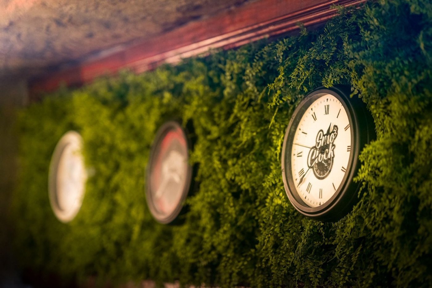 SMOCLOCK branded clock on the moss wall